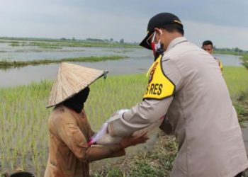 Kapolres OKI, AKBP Alamsyah Palupessy saat menyerahkan bantuan sosial kepada masyarakat yang tinggal di pinggiran Tol Kayuagung, Senin (15/06). (IST)