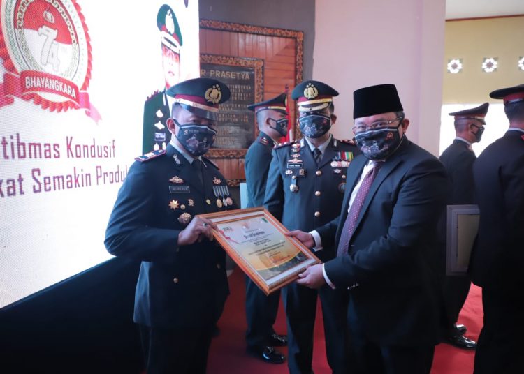 Bupati Muba Dodi Reza Alex didampingi Kapolres Muba AKBP Yudhi SM Pinem menyerahkan piagam penghargaan kepada jajaran Polres Muba yang menorehkan prestasi dalam melaksanakan tugas menjaga Kamtibmas di Muba pada upacara peringatan HUT ke-74 Bhayangkara, di aula Alex Noerdin Mapolres Muba, Rabu (01/07). (fornews.co/humas pemkab muba)