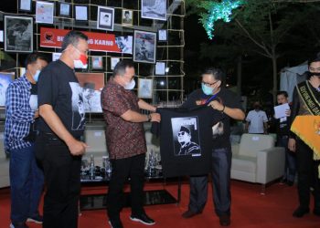 Ketua DPD PDI Perjuangan Sumsel Giri Ramanda Kiemas menyerahkan kaos bergambar Bung Karno kepada Bupati Muba Dodi Reza Alex pada malam puncak peringatan Bulan Bung Karno di waterfront Sekayu, Senin (27/07) malam. (fornews.co/humas pemkab muba)