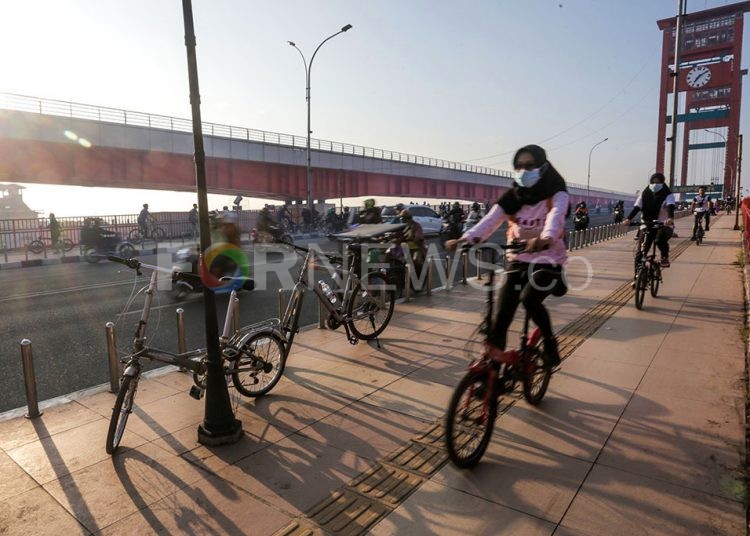 Sejumlah warga dari wilayah Ilir dan Ulu Palembang yang tetap berolahraga sepeda melintasi Jembatan Ampera, Minggu (12/7/2020). (fornews.co/mushaful imam/mata kamera)