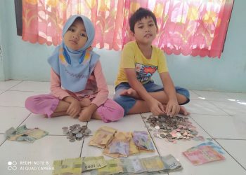 Amir Althaf Habibi (kanan) didampingi adiknya Nayra Sabila (kiri) saat membongkar celengan demi berkurban. Foto: Istimewa/Fornews.co