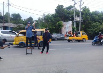 Aksi teatrikal yang dilakukan oleh dua relawan Paslon Bupati dan wakil Bupati Ilyas-Endang di depan gerbang kantor KPU dan Bawaslu Ogan Ilir, Rabu (14/10). (IST)