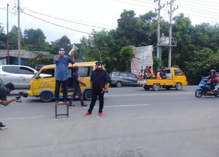 Aksi teatrikal yang dilakukan oleh dua relawan Paslon Bupati dan wakil Bupati Ilyas-Endang di depan gerbang kantor KPU dan Bawaslu Ogan Ilir, Rabu (14/10). (IST)