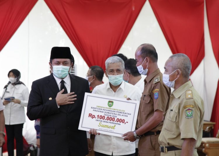 Gubernur Sumsel Herman Deru didampingi Bupati OKI Iskandar menyerahkan secara simbolis Bantuan Keuangan Pemprov Sumsel kepada Desa Persiapan, di Griya Agung Palembang, Rabu (07/10). (fornews.co/humas provinsi sumsel)
