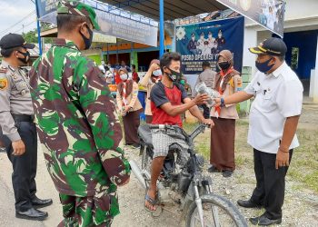 Camat Bayung Lencir M Imron membagikan hadiah kepada pengendara yang memakai masker saat melintas di Posko Operasi Yustisi Desa Sukajaya, Kecamatan Bayung Lencir, Rabu (07/10). (fornews.co/humas pemkab muba)