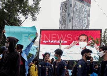 Seorang peserta aksi tolak Omnibus Law UU Cipta Kerja di Palembang melepas masker saat berkerumun, Rabu (07/10). (matakamera/fornews.co/mushaful imam)