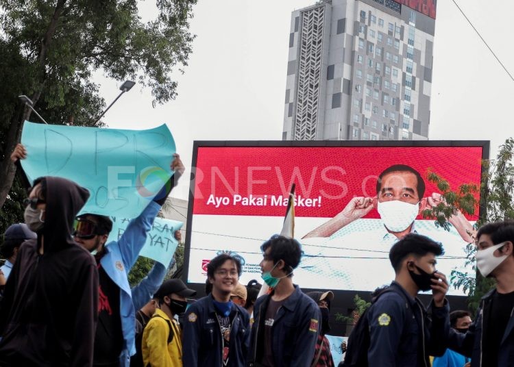 Seorang peserta aksi tolak Omnibus Law UU Cipta Kerja di Palembang melepas masker saat berkerumun, Rabu (07/10). (matakamera/fornews.co/mushaful imam)