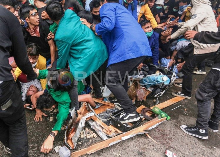 Mahasiswa terinjak dan tertimpa pagar yang roboh akibat massa yang berhamburan keluar setelah polisi menyemprotkan air dari water cannon dan gas air mata untuk membubarkan massa unjuk rasa menuntut pembatalan UU Cipta Kerja di gedung DPRD Sumsel, Kamis (08/10).(matakamera/fornews.co/mushaful imam)