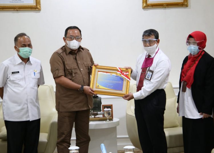 Kepala Kantor Wilayah Ditjen Perbendaharaan Provinsi Sumsel, Taukhid menyerahkan penghargaan dari Menteri Keuangan kepada Pemkab Muba atas raihan opini WTP lima tahun berturut-turut, yang diterima Bupati Muba Dodi Reza Alex di Ruang Audiensi Bupati Muba, Senin (26/10). (fornews.co/humas pemkab muba)