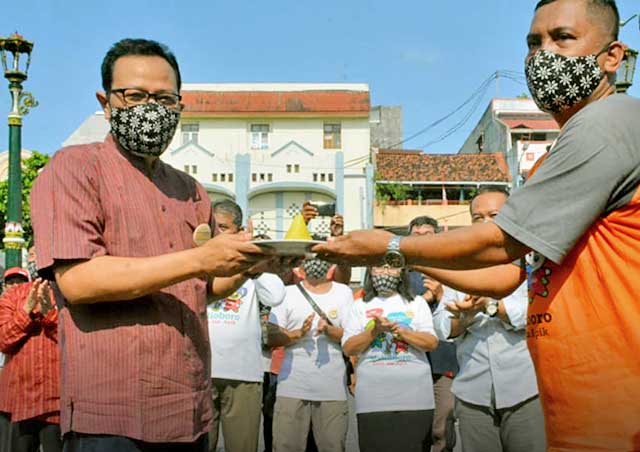 WAKIL Wali Kota Yogyakarta, Heroe Poerwadi, menerima potongan tumpeng dari komunitas ankringan Malioboro. (foto fornews.co)
