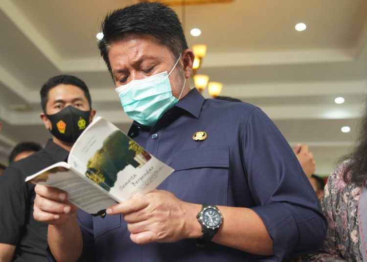 Gubernur Sumsel Herman Deru menyempatkan membaca buku novel pada pembukaan Festival Literasi Sumsel di Griya Agung Palembang, Senin (02/11). (fornews.co/humas provinsi sumsel)