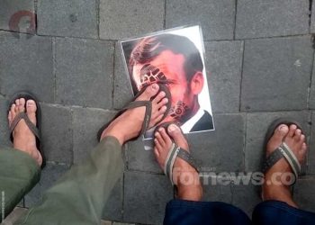DUA kaki dari para demonstran di Yogyakarta menginjakkan kakinya di foto berwajah Presiden Prancis, Emmanuel Macron, sebangai bentuk protes terhadap penghinaan Nabi Muhammad. (foto fornews.co/adam)