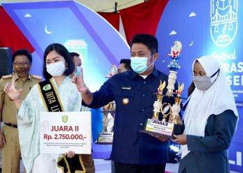 Gubernur Sumsel Herman Deru dan Duta Literasi Sumsel Percha Leanpuri menyerahkan trofi dan hadiah kepada Juara II lomba video pendek pekan literasi Sumsel, Senin (02/11). (fornews.co/humas provinsi sumsel)