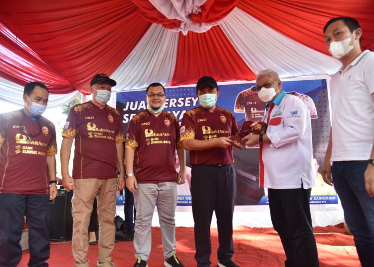 Gubernur Sumsel Herman Deru menyerahkan jersei Sriwijaya FC kepada Dirut BSB Ahmad Syamsuddin selaku salah satu sponsor Sriwijaya FC pada peresmian penjualan jersei orisinal terbaru Sriwijaya FC di Kambang Iwak Palembang, Minggu (15/11). (fornews.co/humas provinsi sumsel)