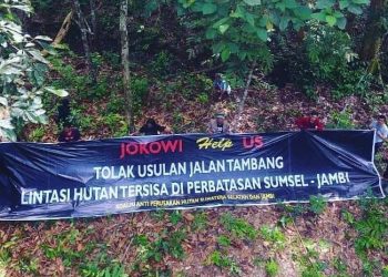 Forum Masyarakat Penyelamat Hutan Alam Sumatra Selatan-Jambi membentangkan baleho penolakan jalan angkut batu bara yang melintasi hutan di perbatasan Sumsel-Jambi, beberapa waktu lalu. (fornews.co/ist)