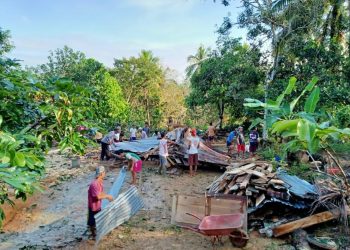 Warga Dusun III Desa Warga Mulyo Kecamatan Plakat Tinggi bergotong royong membersihkan puing-puing rumah milik kakek Khozin yang hancur tertimpa pohon tumbang, Sabtu (14/11). (fornews.co/humas pemkab muba)