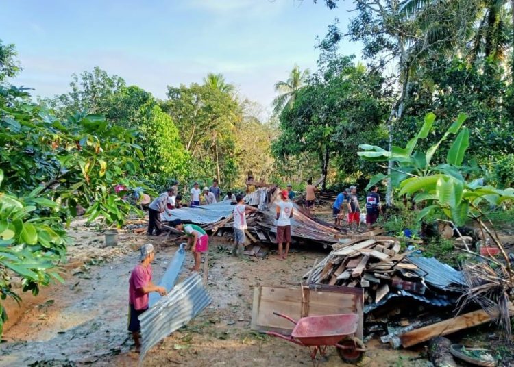 Warga Dusun III Desa Warga Mulyo Kecamatan Plakat Tinggi bergotong royong membersihkan puing-puing rumah milik kakek Khozin yang hancur tertimpa pohon tumbang, Sabtu (14/11). (fornews.co/humas pemkab muba)