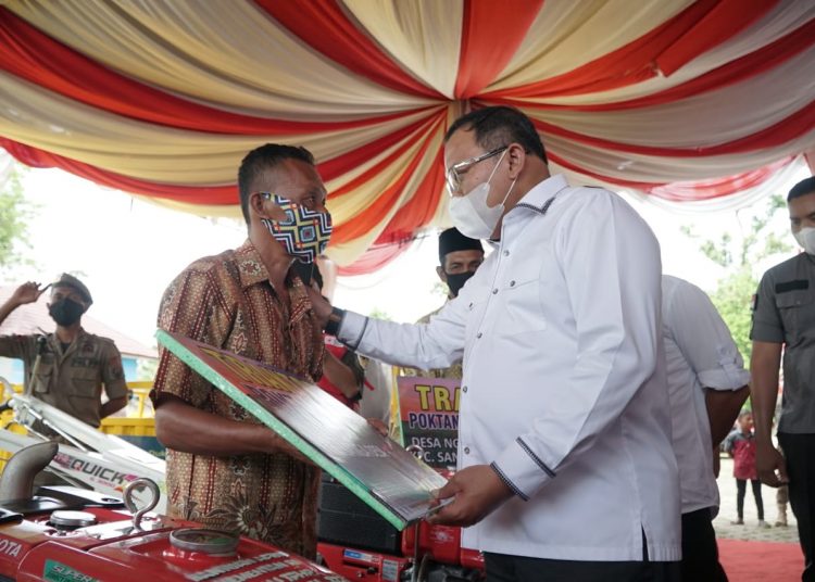 Bupati Muba Dodi Reza Alex saat menyerahkan bantuan traktor tangan kepada salah satu perwakilan kelompok tani di Kecamatan Sanga Desa, Kamis (26/11). (fornews.co/humas pemkab muba)
