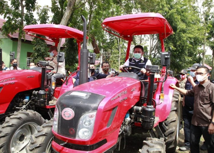 Gubernur Sumsel Herman Deru, menaiki traktor bantuan Kementerian Pertanian, usai menyerahkan kepada kelompok petani Kota Pagaralam, Sabtu (26/12). (fornews.co/humas pemprov sumsel) 