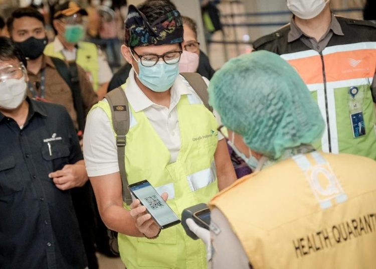 Menparekraf Sandiaga Salahuddin Uno saat diperiksa formulir deklarasi kesehatan setibanya di Bandar Udara Internasional I Gusti Ngurah Rai, Minggu (27/12). (fornews.co/humas kemenparekraf)