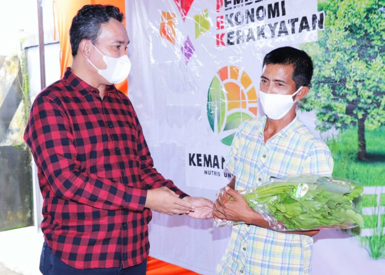 Wakil Bupati Muba Beni Hernedi saat menyerahkan hasil panen sayuran kepada warga yang menandai diresmikannya Program Kemitraan di Sektor Urban Farming dari Kemang Farm di Dusun IV Desa Kemang, Kecamatan Sanga Desa, Sabtu (5/12). (fornews.co/humas pemkab muba)