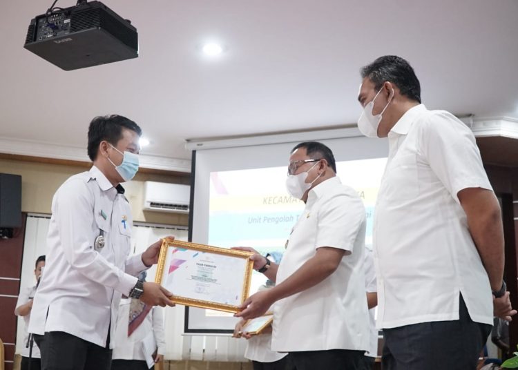 Bupati Muba Dodi Reza Alex didampingi Wakil Bupati Muba Beni Hernedi menyerahkan piagam penghargaan kepada Camat Jirak Jaya Yudi Suhendra yang menjadi terbaik I tingkat kecamatan Kategori Unit Pengolah Terbaik pada pengelolaan kearsipan, Selasa (8/12). (fornews.co/humas pemkab muba)