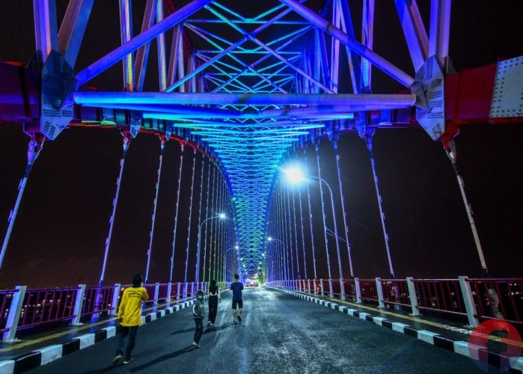 Warga berada di atas Jembatan Musi VI yang dilengkapi dengan gemerlap lampu LED yang dialiri listrik PLN. (matakamera/fornews.co/mushaful imam)