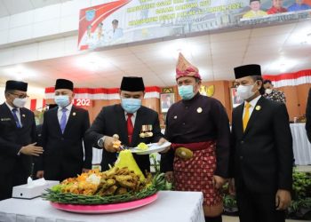 Gubernur Sumsel Herman Deru menyaksikan Bupati Ogan Ilir Ilyas Panji Alam memotong tumpeng pada peringatan HUT ke-17 Kabupaten Ogan Ilir, Kamis (7/1/2021). (fornews.co/kominfo sumsel)