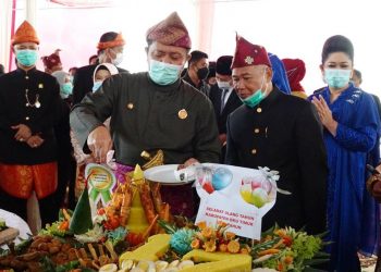 Gubernur Sumsel Herman Deru didampingi Bupati OKU Timur Kholid Mawardi memotong tumpeng pada peringatan HUT ke-17 Kabupaten OKU Timur, Senin (18/1/2021). (fornews.co/humas provinsi sumsel)