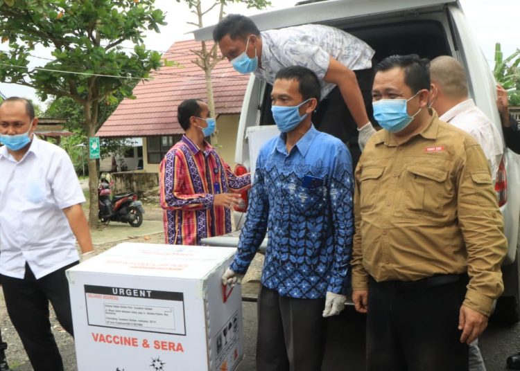 Petugas saat memindahkan Vaksin Sinovac dari mobil ke tempat penyimpanan, Jumat (29/01). (Diskominfo OKU Selatan)
