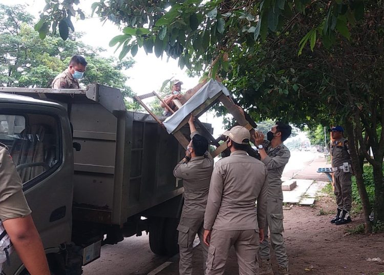 Petugas Sat Pol PP Kota Palembang menertibkan lapak PKL yang berjualan di pinggir Jalan Demang Lebar Daun, Kamis (14/1/2021). (fornews.co/bakohumas palembang)