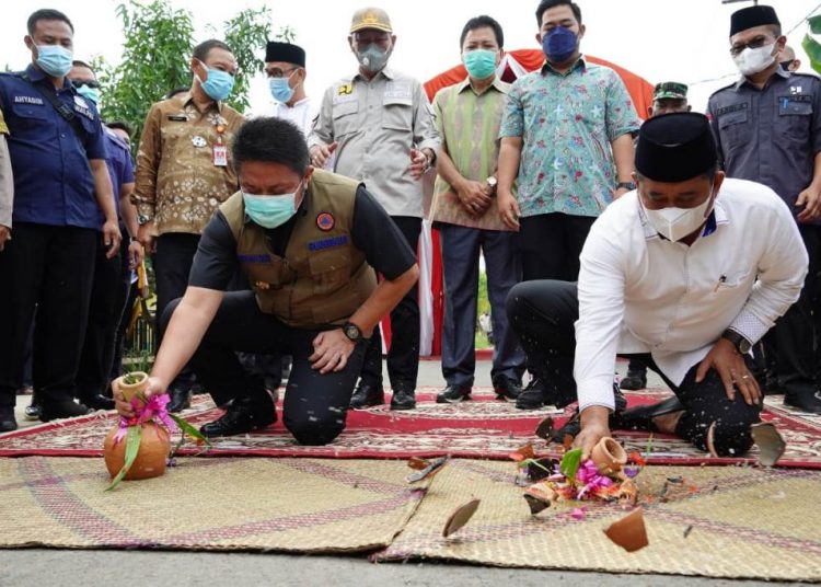 Gubernur Sumsel Herman Deru dan Bupati Banyuasin Askolani memcahkan kendi menandai peresmian Jalan Merah Mata yang diperbaiki tahun 2020, Jumat (22/1/2021). (fornews.co/humas provinsi sumsel)
