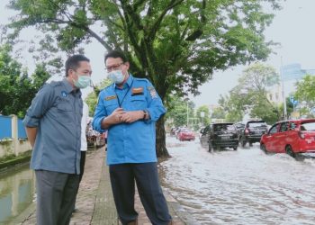 Sekda Palembang Ratu Dewa berdiskusi dengan Kepala Dinas PUPR Kota Palembang Akhmad Bastari saat meninjau genangan air di Jalan Residen H Abdul Rozak, Senin (18/1/2021). (fornews.co/bakohumas palembang)
