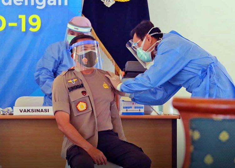 SEORANG anggota Polri DIY menerima vaksinasi dari petugas tim kesehatan di Bagsal Kepatihan Yogyakarta, pada Kamis (14/1/2021). (foto polda diy)
