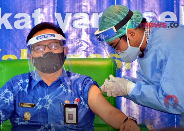 SEORANG petugas dari tim tenaga kesehatan sedang melakukan vaksinasi kepada Wakil Wali Kota Yogakarta, Heroe Poerwadi, di Rumah Sakit Pratama, Jum'at (15/1/2021). (foto fornews.co)