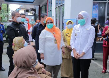 Wawako Palembang Fitrianti Agustinda menyapa tenaga kesehatan yang sedang menunggu antrean untuk divaksinasi Covid-19 di halaman Puskesmas Merdeka, Senin (18/1/2021). (fornews.co/bakohumas palembang)