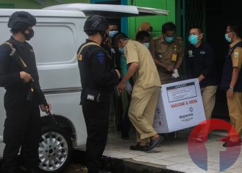 Petugas dari Sat Brimob Polda Sumsel melakukan pengamanan saat pemindahan vaksin dari Gudang Farmasi Dinkes Provinsi Sumsel. (matakamera/fornews.co/mushaful imam)