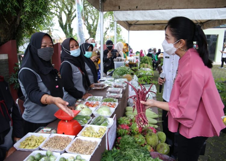 Ketua TP PKK Kabupaten Muba Thia Yufada Dodi Reza saat menawar sayur dari salah satu lapak di Pasar Tani KWT tahun 2021 di halaman kantor sekretariat TP PKK Kabupaten Muba, Rabu (13/1/2021). (fornews.co/humas pemkab muba)