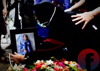 Yusrilanita, ibunda Indah Halimah Putri memeluk foto anaknya di atas pusara usai dimakamkan. (matakamera/fornews.co/mushaful imam)