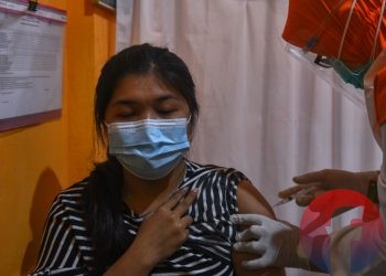 Seorang tenaga kesehatan dari sebuah rumah sakit swasta sedang disuntik vaksin Covid-19 di Puskesmas Merdeka Palembang, Senin (18/1/2021). (matakamera/fornews.co/mushaful imam)