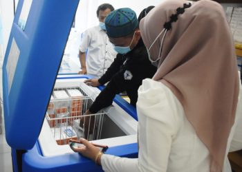 Petugas Dinas Kesehatan Kabupaten Muba menyimpan vaksin Covid-19 di kotak pendingin di Gudang Farmasi Dinkes Muba, Senin (25/1/2021). (fornews.co/humas pemkab muba)