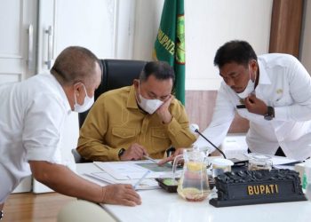 Bupati Muba Dodi Reza Alex mendapat penjelasan dari Kepala Bappeda Muba Iskandar Syahrianto mengenai konektivitas exit Jalan Tol Trans Sumatra yang melintasi wilayah Muba dengan jalur segitiga emas Muba saat mengikuti rapat Percepatan Pembangunan Jalan Tol di Provinsi Sumatra Selatan yang dilakukan secara virtual, Rabu (27/1/2021). (fornews.co/humas pemkab muba)