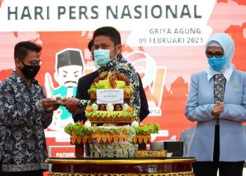Gubernur Sumsel Herman Deru menyerahkan potongan tumpeng kepada Ketua PWI Sumsel Firdaus Komar pada peringatan HPN Tahun 2021 di Griya Agung Palembang, Selasa (9/2/2021). (fornews.co/humas provinsi sumsel)