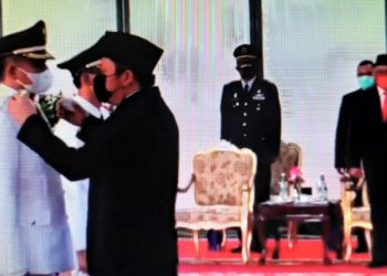 Gubernur Sumsel, Herman Deru menyematkan cupu ke Bupati OKU Timur, Lanosin, yang tak lain adalah adik kandung Herman Deru, di Griya Agung, Jumat (26/2/2021) siang. (fornews.co/repro)