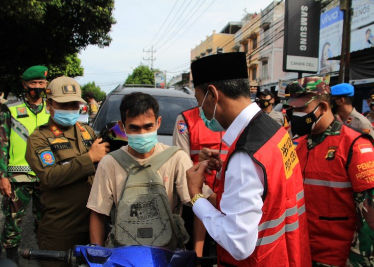 Wakil Bupati OKI, H M Dja'far Shodiq memberikan masker kepada salah seorang warga. (IST)
