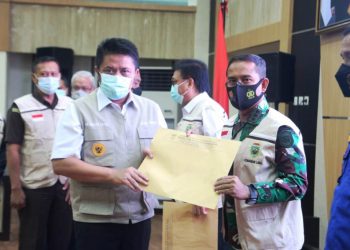 Gubernur Sumsel Herman Deru menyerahkan SK Pembentukan Satgas PBBKB Perairan Sumsel kepada Danlanal Palembang Kolonel Laut (P) Filda Malari pada pengukuhan Satgas PBBKB di auditorium Pemprov Sumsel, Kamis (11/2/2021). (fornews.co/humas provinsi sumsel)