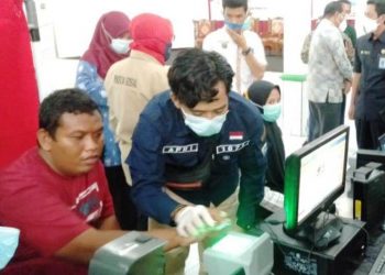 Seorang penyandang disabilitas dibantu petugas Dinas Dukcapil Palembang melakukan perekaman data e-KTP di Balai Rehabilitasi Sosial Penyandang Disabilitas Fisik Budi Perkasa, Kamis (25/2/2021). (fornews.co/bakohumas palembang)