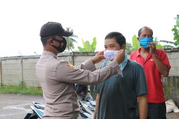 Anggota Polres Lahat memasangkan masker ke masyarakat yang kedapatan beraktivitas di luar rumah tanpa mengenakan masker, Senin (8/2/2021). (fornews.co/humas polres lahat)