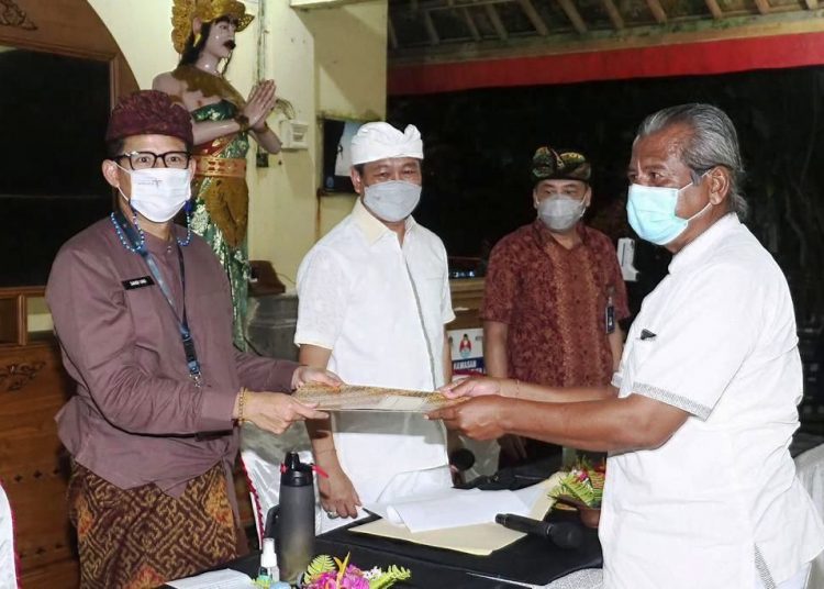 Menparekraf Sandiaga Salahuddin Uno menerima proposal yang diajukan perwakilan Desa Wisata Kutuh yang saat ini dalam kondisi darurat karena pendapatan dari sektor pariwisata menurun drastis saat melakukan peninjauan ke Desa Wisata Kutuh, Kabupaten Badung, Bali, Kamis malam (11/2/2021). (fornews.co/humas kemenparekraf)