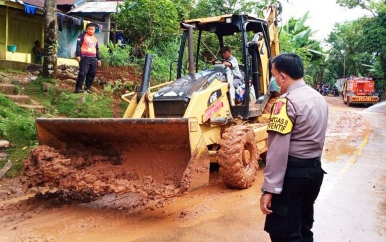 Alat berat membersihkan tanah yang menutupi badan jalan di Desa Kebur, Kecamatan Tiang Pumpung Kepungut, Kabupaten Musi Rawas, Sabtu (13/2/2021). (fornews.co/humas polres mura)